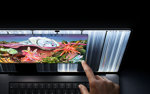 جهاز MacBook Pro مع شاشة PROLED XDR، لون أسود فلكي، مستخدم يغيّر حجم نافذة على الشاشة بطرف إصبعه