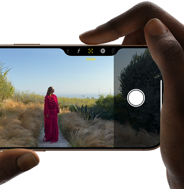 User holding iPhone 16 Pro and taking a photograph